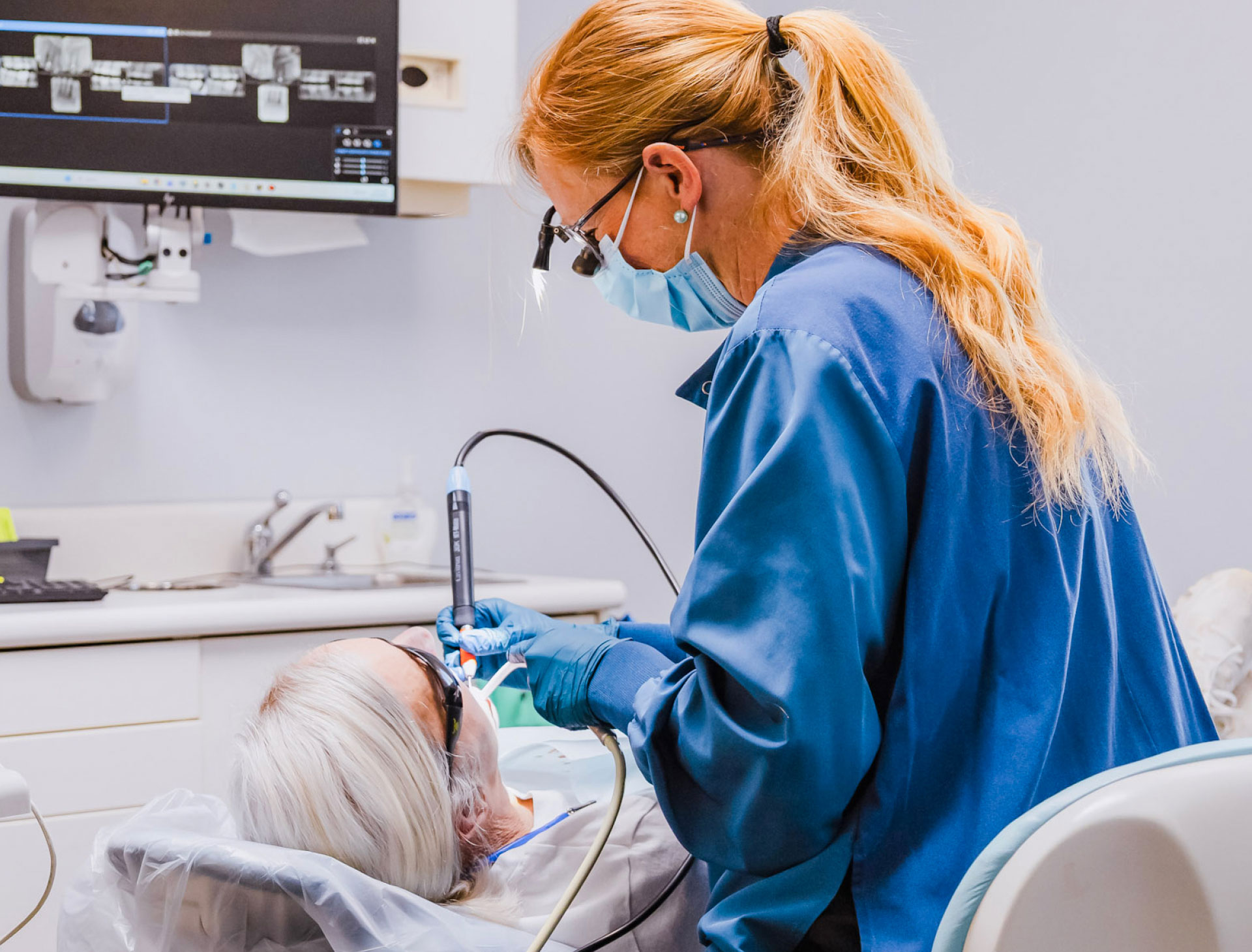 dental assistant performing bonding procedure on patient