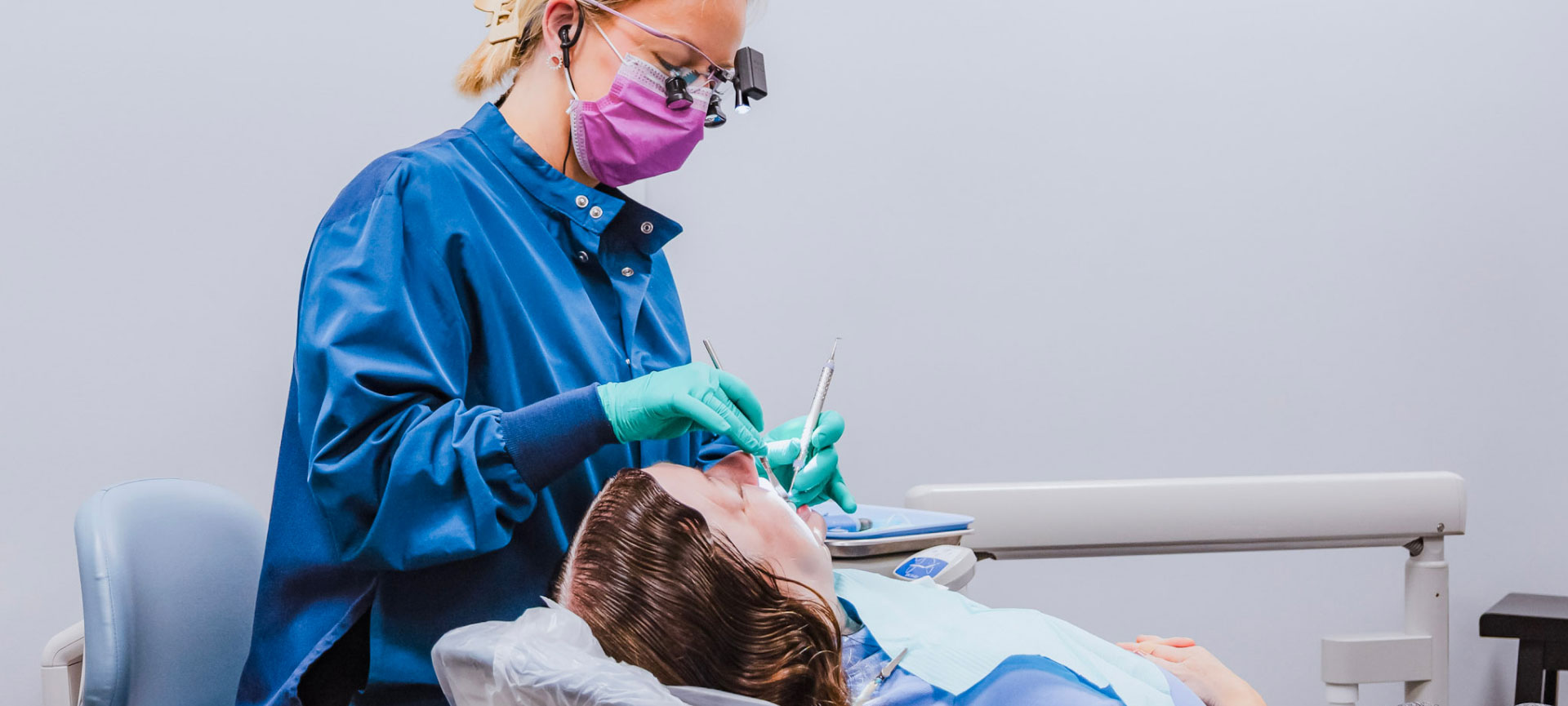 dental hygienist performing periodontal procedure on patient