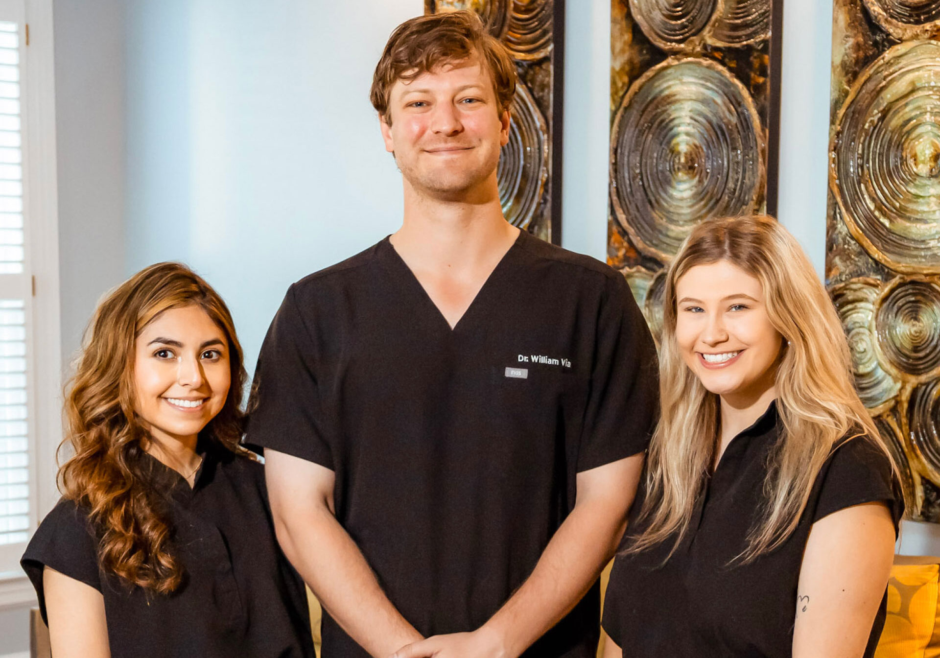 Dr. Via and assistants posing for photo in reception area